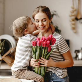 Maman et son fils se font un câlin avec des tulipes 